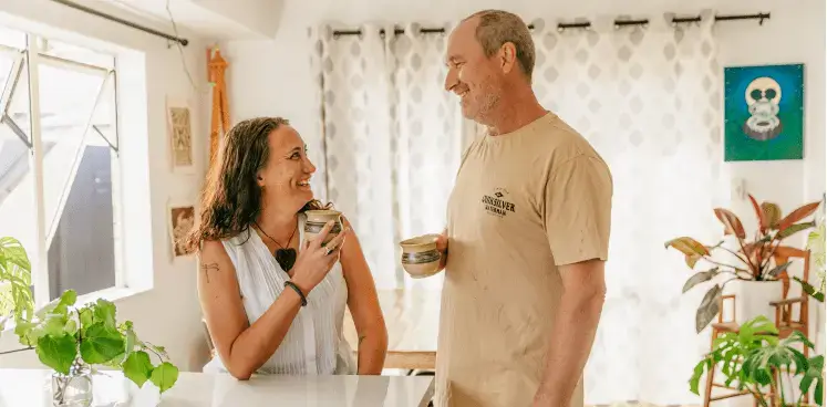 Man and woman smiling at each other in earthy bright kitchen